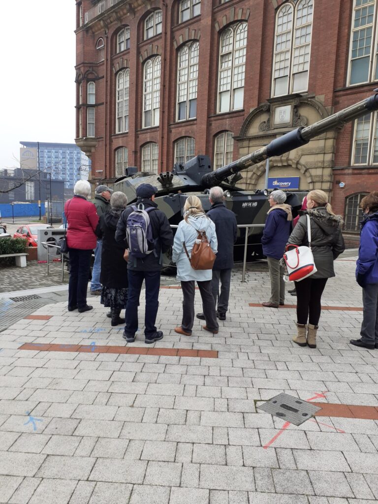 people looking at tank outside a museum