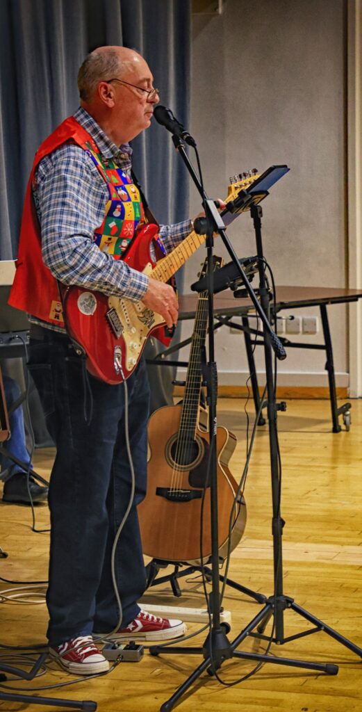 Gerald playing guitar and singing